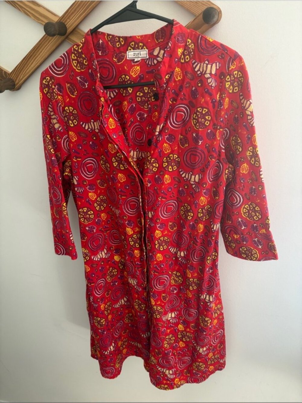 Zuri red shirt dress features a vibrant "Pilau" garlic and ginger pattern